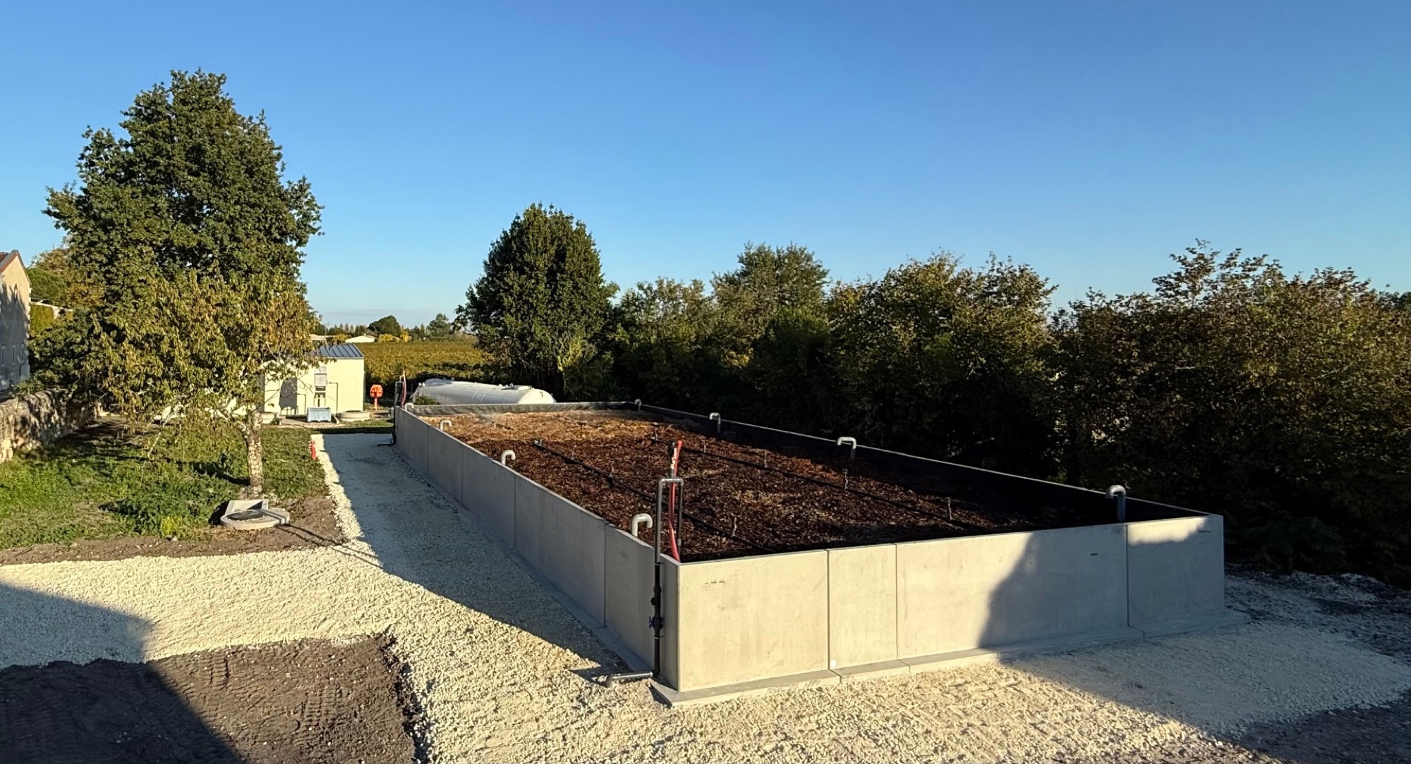 Bassin de vermifiltration BIDA en extérieur, rampe d'aspersion et substrat organique